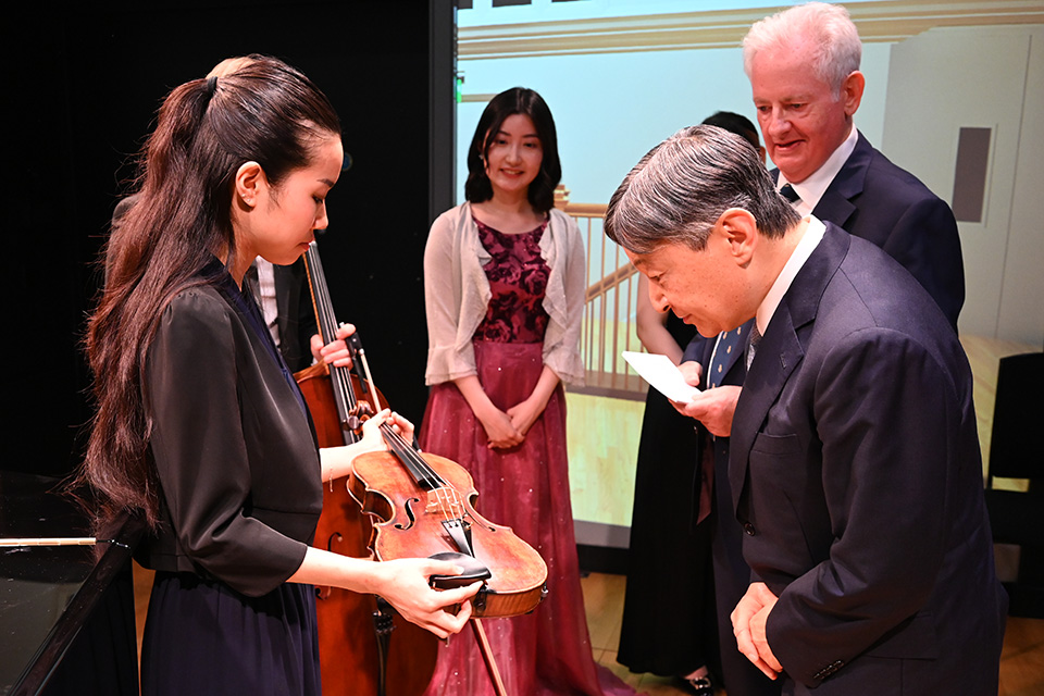 A student showing a viola to His Majesty The Emperor